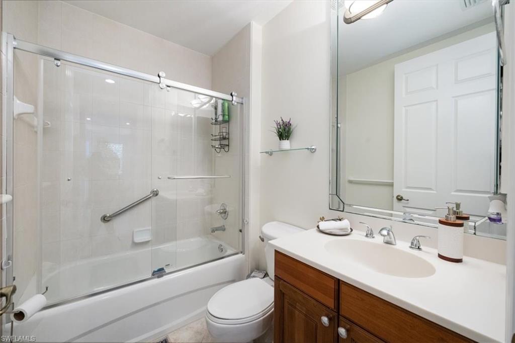 Full bath featuring enclosed tub / shower combo and vanity