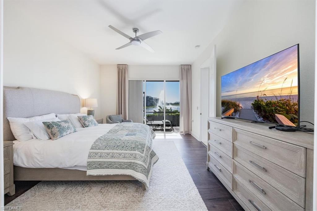 Bedroom with access to exterior, dark wood-style flooring, and a ceiling fan