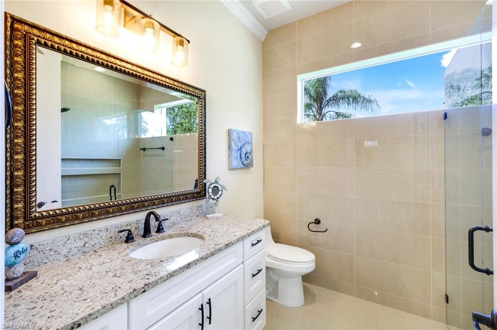 Full bath with vanity, a stall shower, and light tile patterned floors