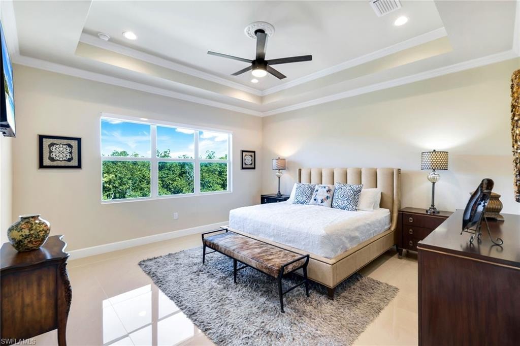 Bedroom featuring a tray ceiling, crown molding, ceiling fan, recessed lighting, and light tile patterned floors