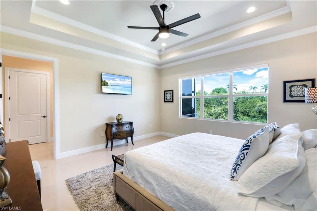 Bedroom with a raised ceiling, crown molding, recessed lighting, and ceiling fan