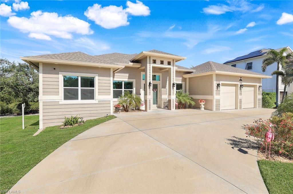 Prairie-style house with concrete driveway, a shingled roof, an attached garage, and a front lawn
