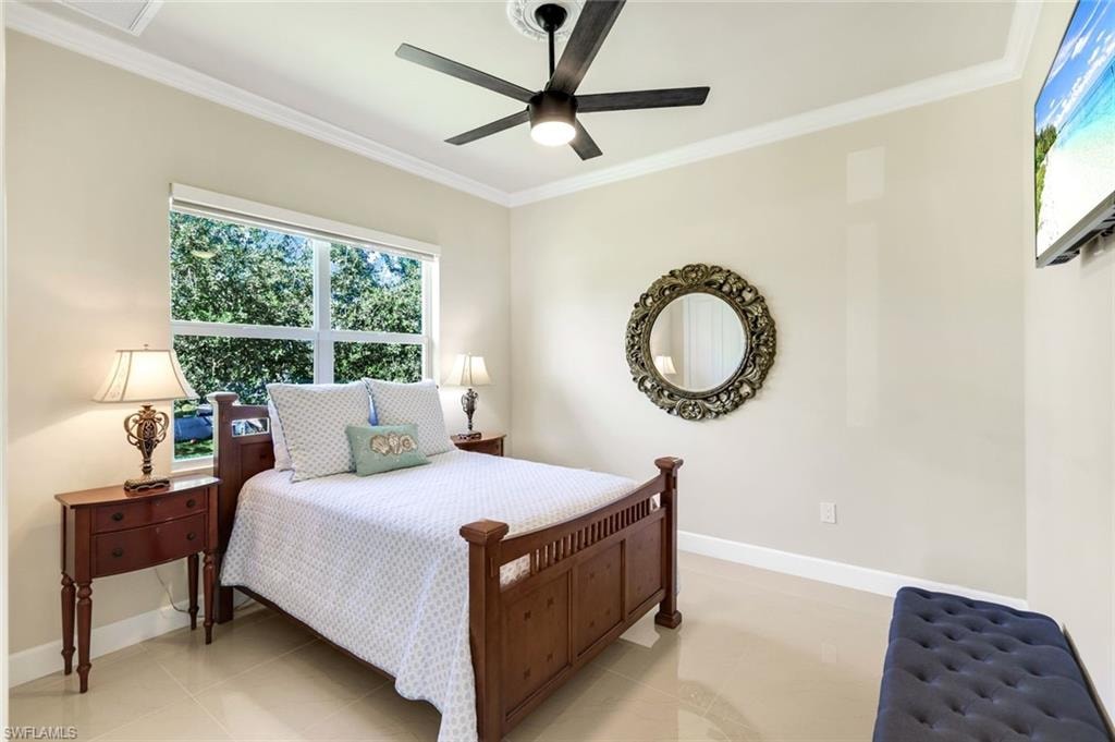 Bedroom featuring multiple windows, crown molding, ceiling fan, and light tile patterned floors