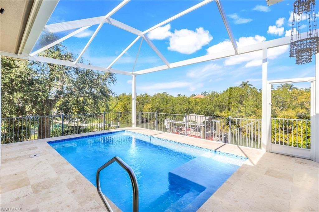 View of pool with a lanai, a sunroom, and view of scattered trees