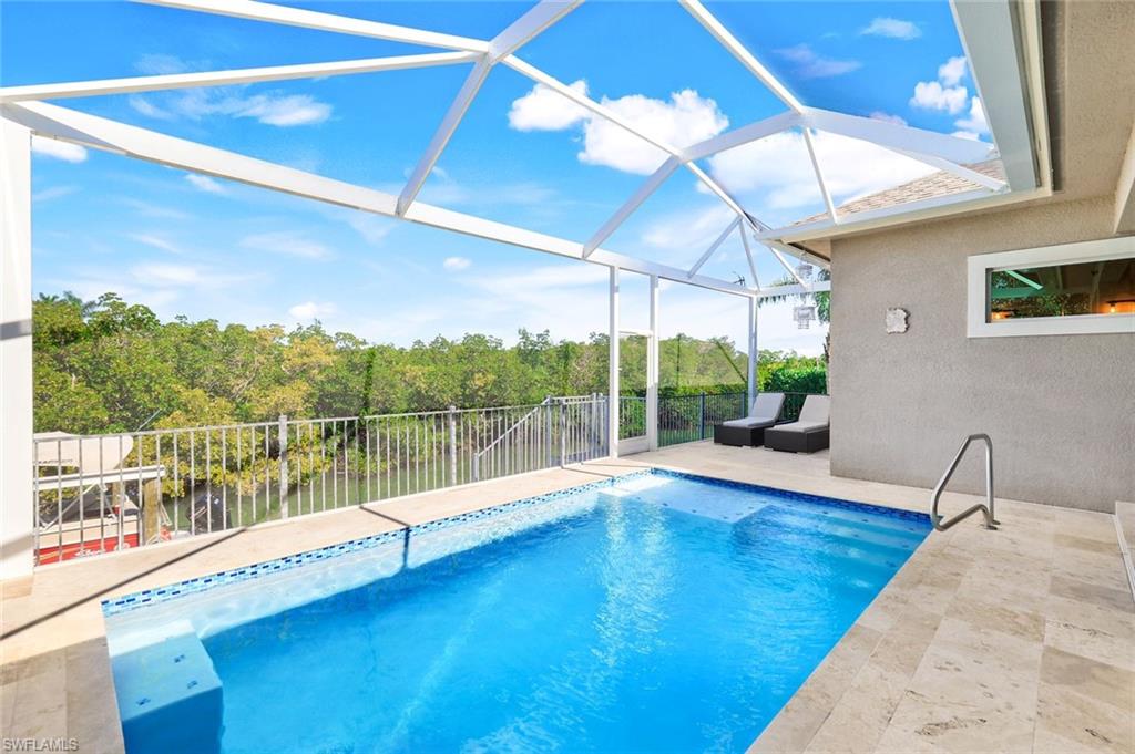 View of swimming pool featuring a sunroom, a patio, and glass enclosure