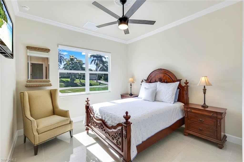Bedroom with ornamental molding, tile patterned flooring, and ceiling fan