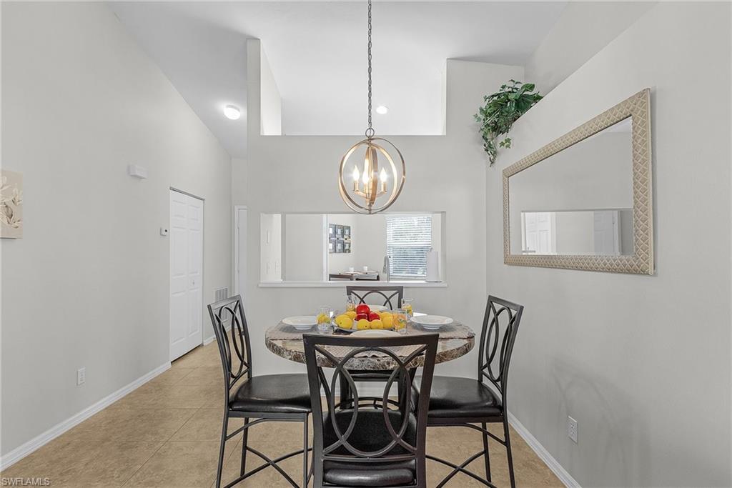 Dining room featuring light tile patterned flooring, a chandelier, recessed lighting, and high vaulted ceiling