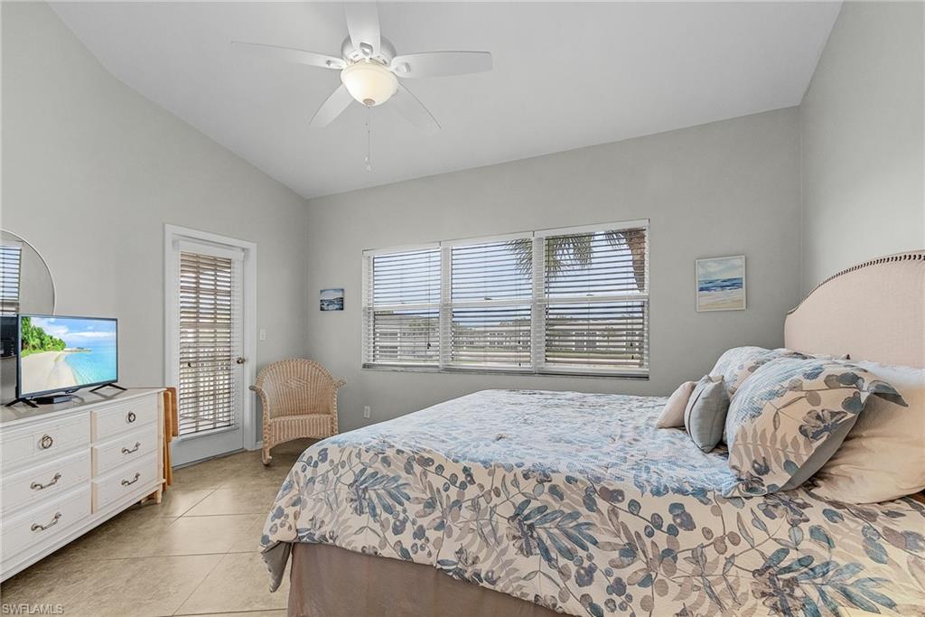 Bedroom featuring light tile patterned flooring, ceiling fan, lofted ceiling, and access to exterior