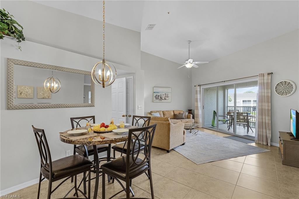 Dining space with ceiling fan, high vaulted ceiling, and light tile patterned floors