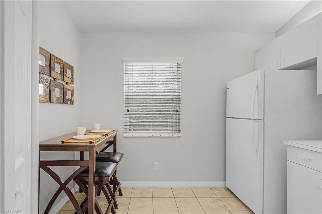 Dining area with light tile patterned floors and baseboards