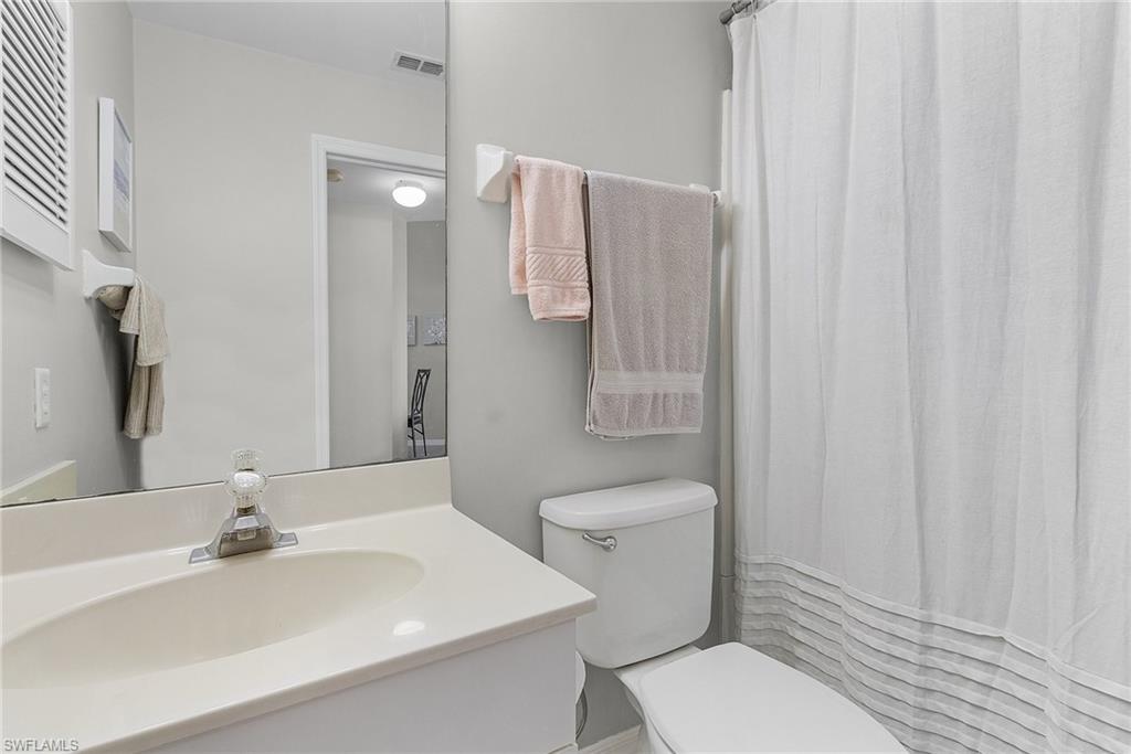 Full bath featuring curtained shower and vanity