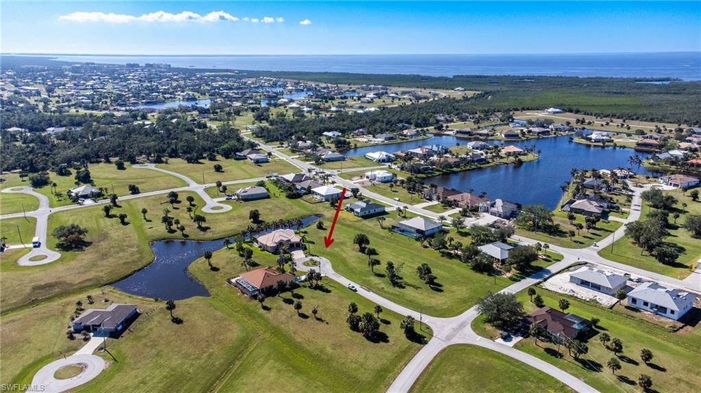 Aerial view of property and surrounding area with a large body of water and nearby suburban area
