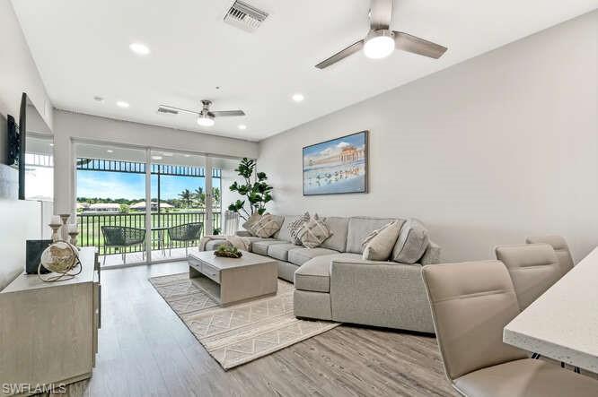 Living room with light wood finished floors, recessed lighting, and a ceiling fan