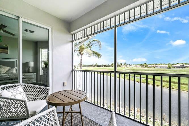 Balcony featuring view of golf course and a water view