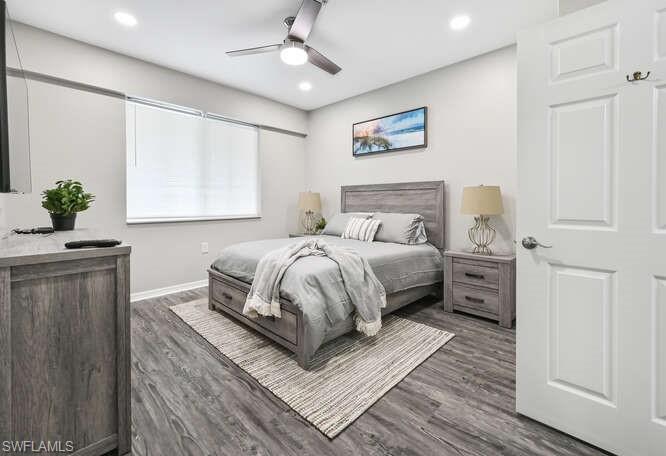 Bedroom with dark wood-style floors, ceiling fan, and recessed lighting