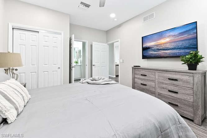 Bedroom with a ceiling fan, a closet, recessed lighting, connected bathroom, and light wood-style flooring