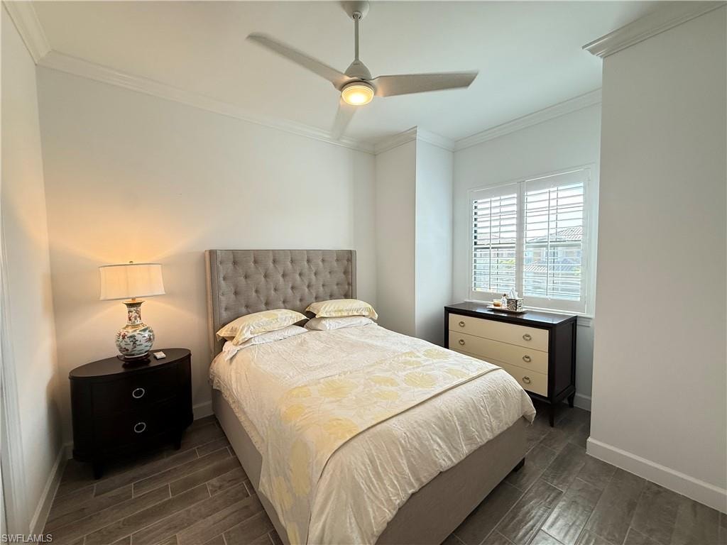 Front guest Bedroom with new bedroom furniture, crown molding, porcelain wood-like flooring, plantation shutters, ceiling fan, and full bath not shown, and plantation shutters