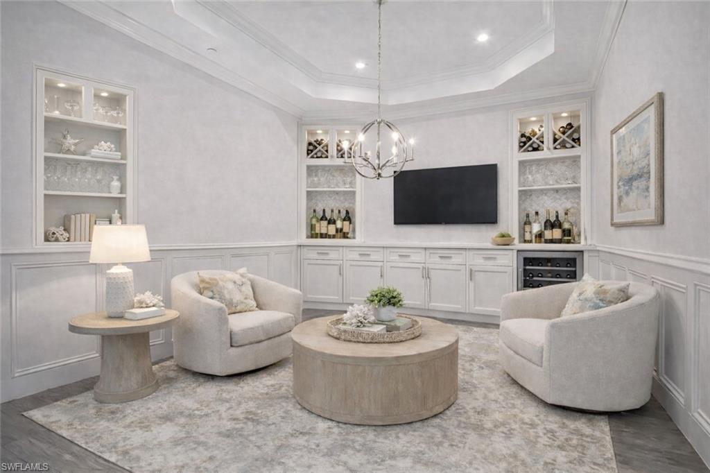 Virtually staged TV/Wine /Dining/Flex Room with beverage cooler, built-in-shelving. Custom Millwork, tray ceiling, crown moulding, and new lighting fixture