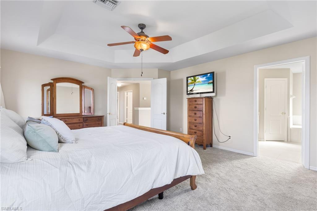 Beautful tray ceiling nhances your primary bedroom.