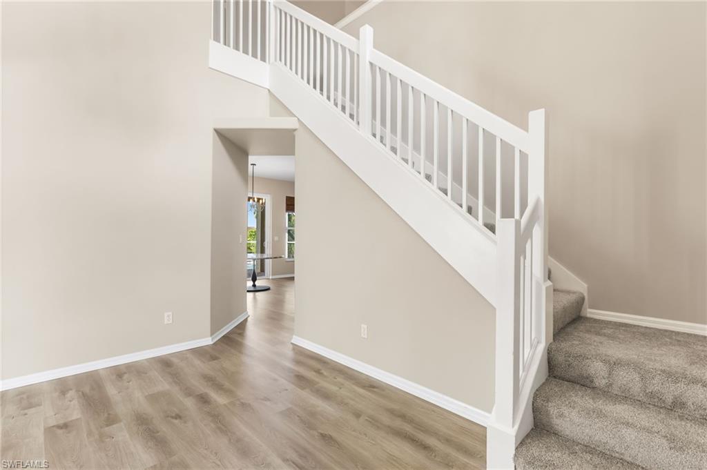 Staircase featuring a high ceiling and wood finished floors