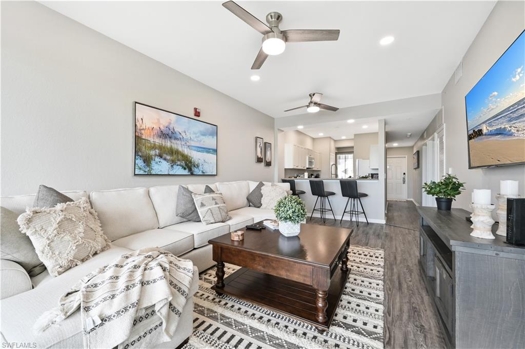Living area with wood finished floors, recessed lighting, and a ceiling fan