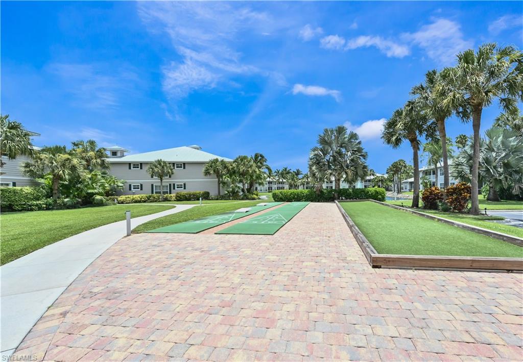 View of property's community with shuffleboard, a bocce ball area, and a yard