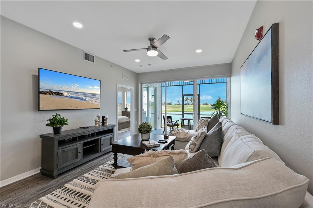 Living room with recessed lighting, a textured wall, a ceiling fan, and wood finished floors