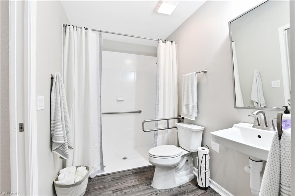 Bathroom featuring a shower stall and wood finished floors