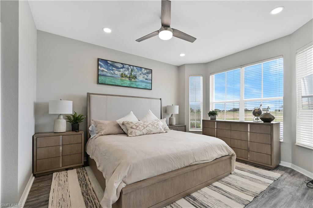Bedroom with wood finished floors, multiple windows, a ceiling fan, and recessed lighting