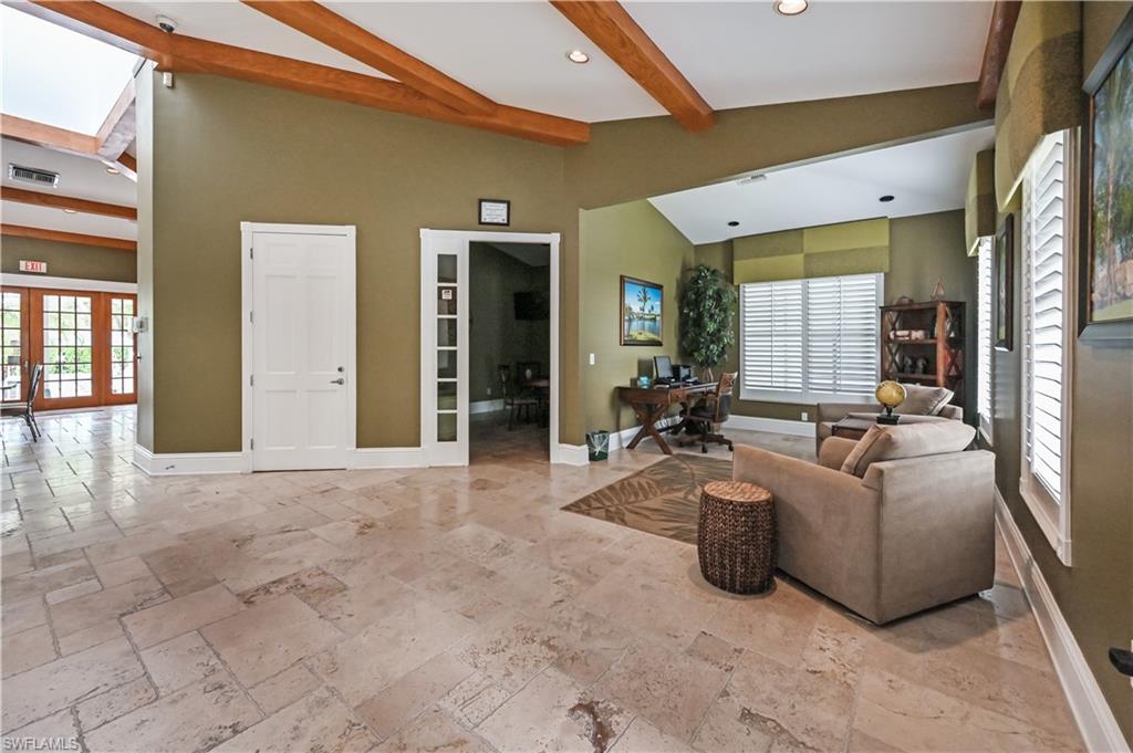 Living area with a desk, healthy amount of natural light, french doors, a skylight, and beamed ceiling