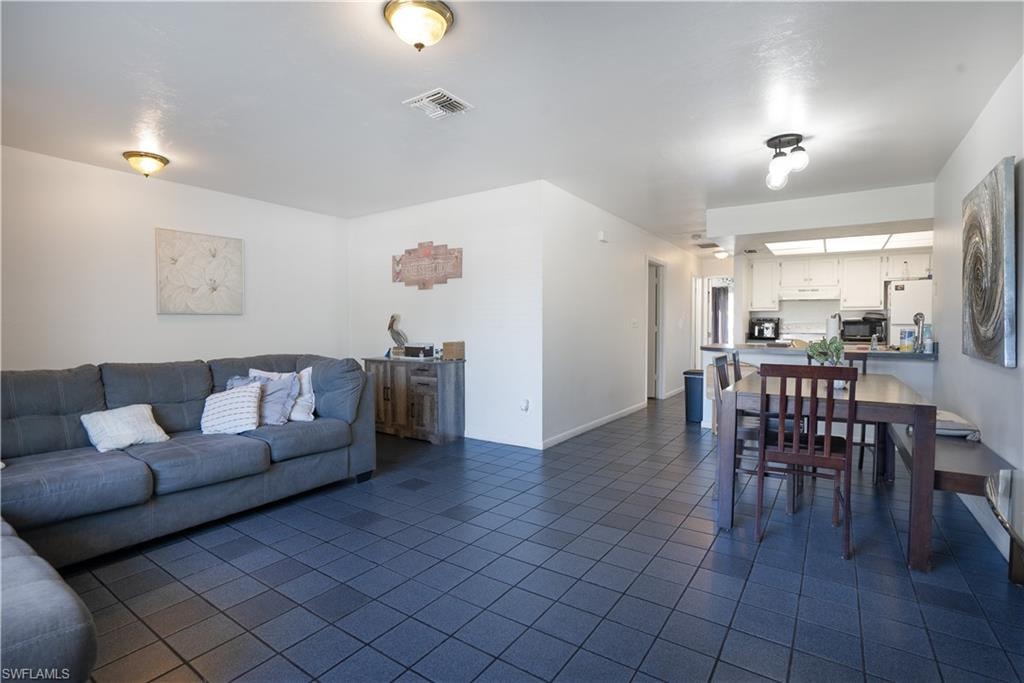 Living room featuring dark tile patterned floors and baseboards