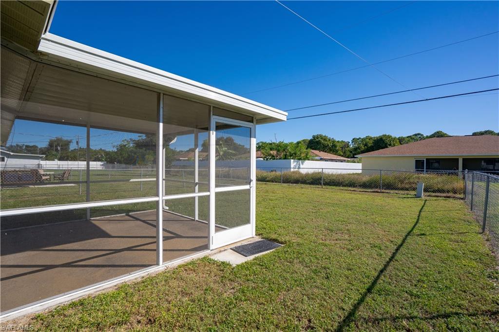 Fenced backyard featuring a sunroom