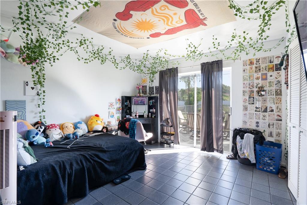Bedroom with access to outside, tile patterned floors, and a heating unit