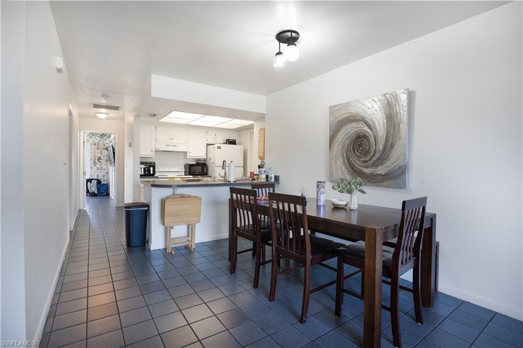 Dining area with dark tile patterned floors and baseboards