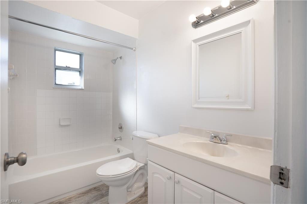 Full bathroom with shower / bathtub combination, vanity, and light wood finished floors