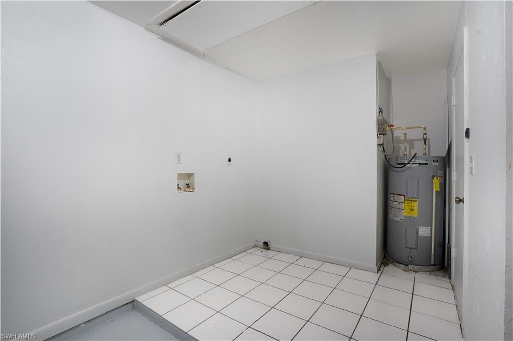Laundry room with water heater, attic access, washer hookup, electric dryer hookup, and light tile patterned floors