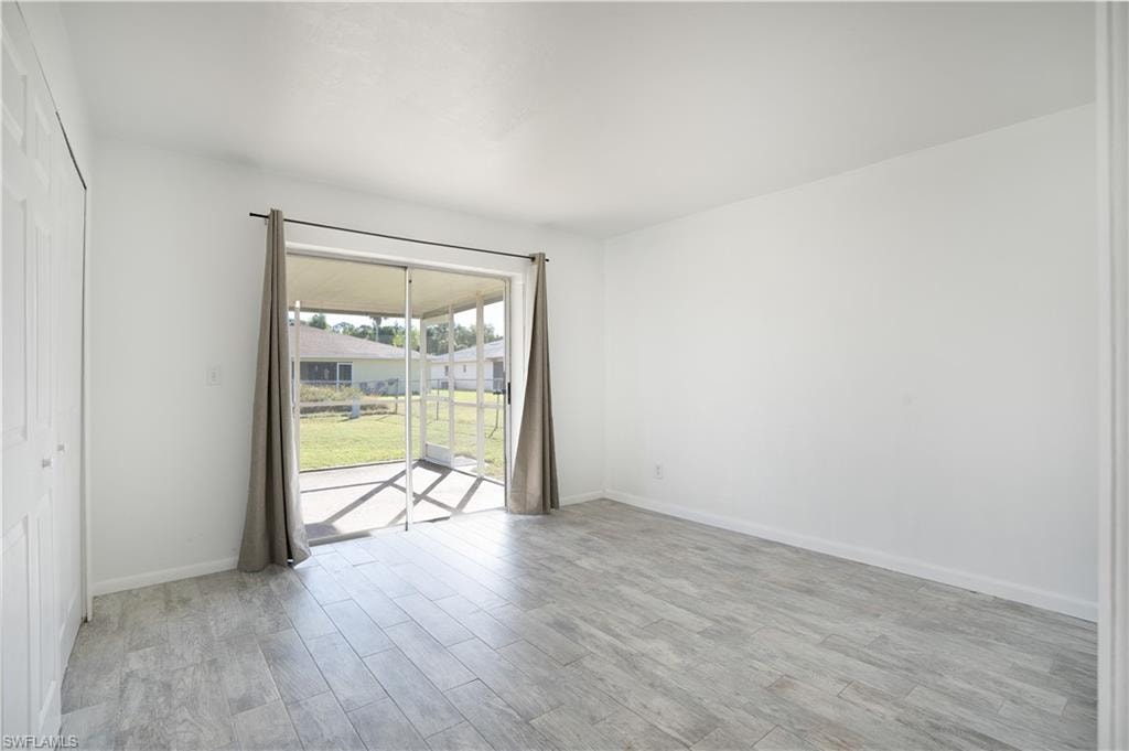 Spare room featuring light wood finished floors and baseboards