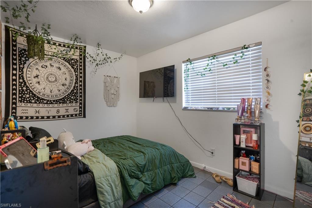 Tiled bedroom featuring baseboards