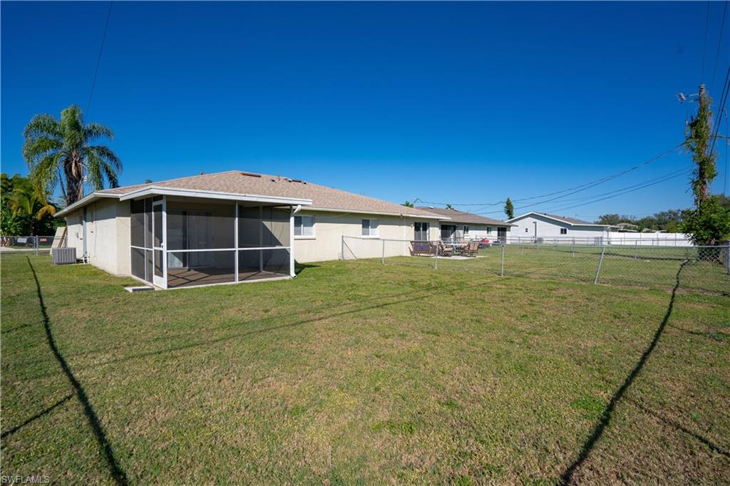 Back of house featuring a fenced backyard and a sunroom