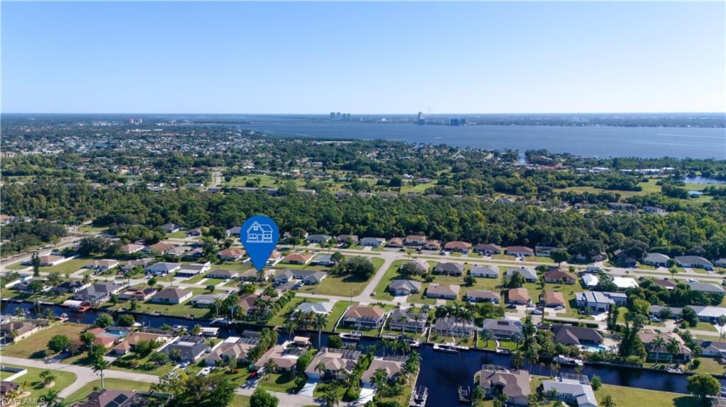 Aerial view of property's location featuring a nearby body of water and nearby suburban area