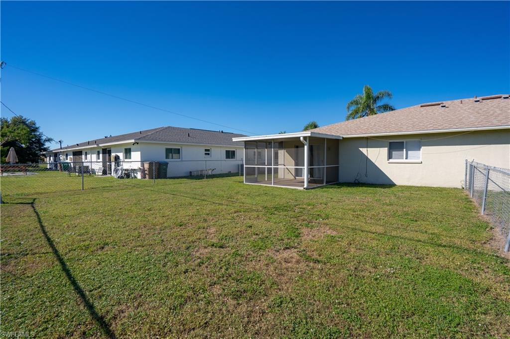 Back of house with a fenced backyard and a sunroom