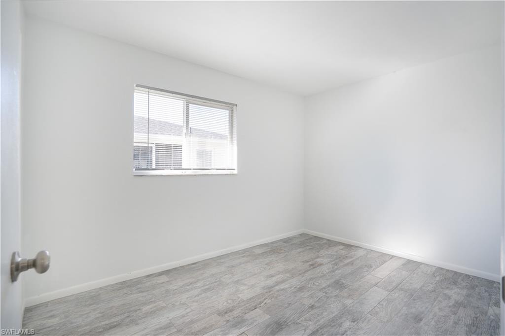 Unfurnished room featuring wood finished floors and baseboards