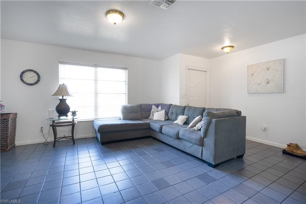 Living room with baseboards and dark tile patterned flooring