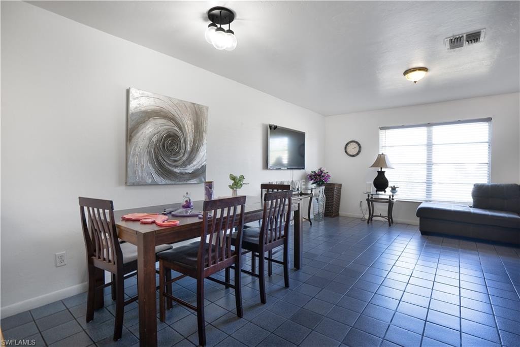 Dining room featuring baseboards and dark tile patterned floors