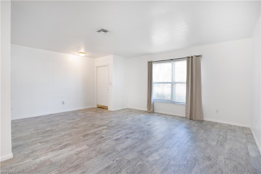 Empty room with light wood finished floors and baseboards