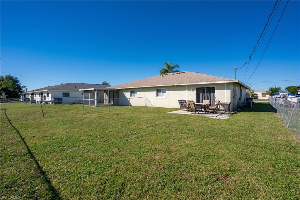 Back of property featuring a fenced backyard, stucco siding, and a patio area