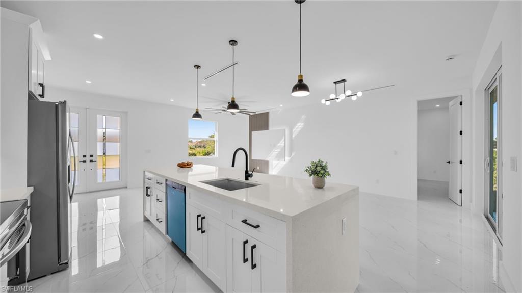 Kitchen featuring white cabinetry, light stone countertops, light marble finish floors, and recessed lighting