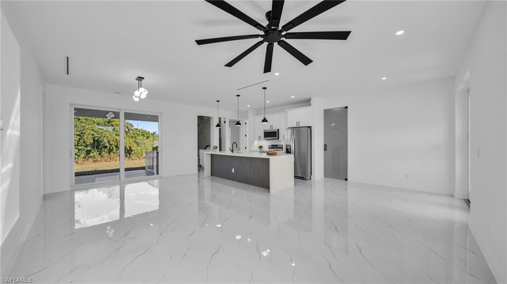 Unfurnished living room featuring recessed lighting, light marble finish flooring, and ceiling fan