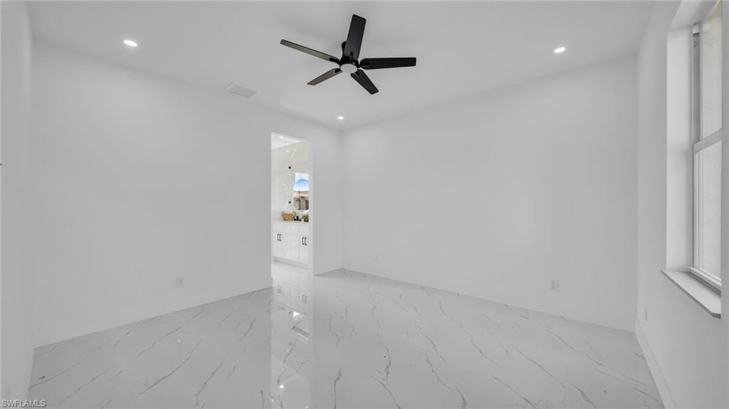 Empty room with light marble finish floors, recessed lighting, and a ceiling fan