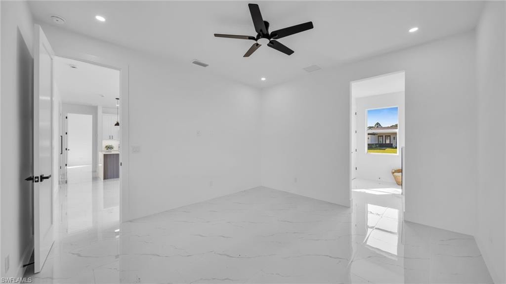 Spare room featuring light marble finish floors, recessed lighting, and ceiling fan